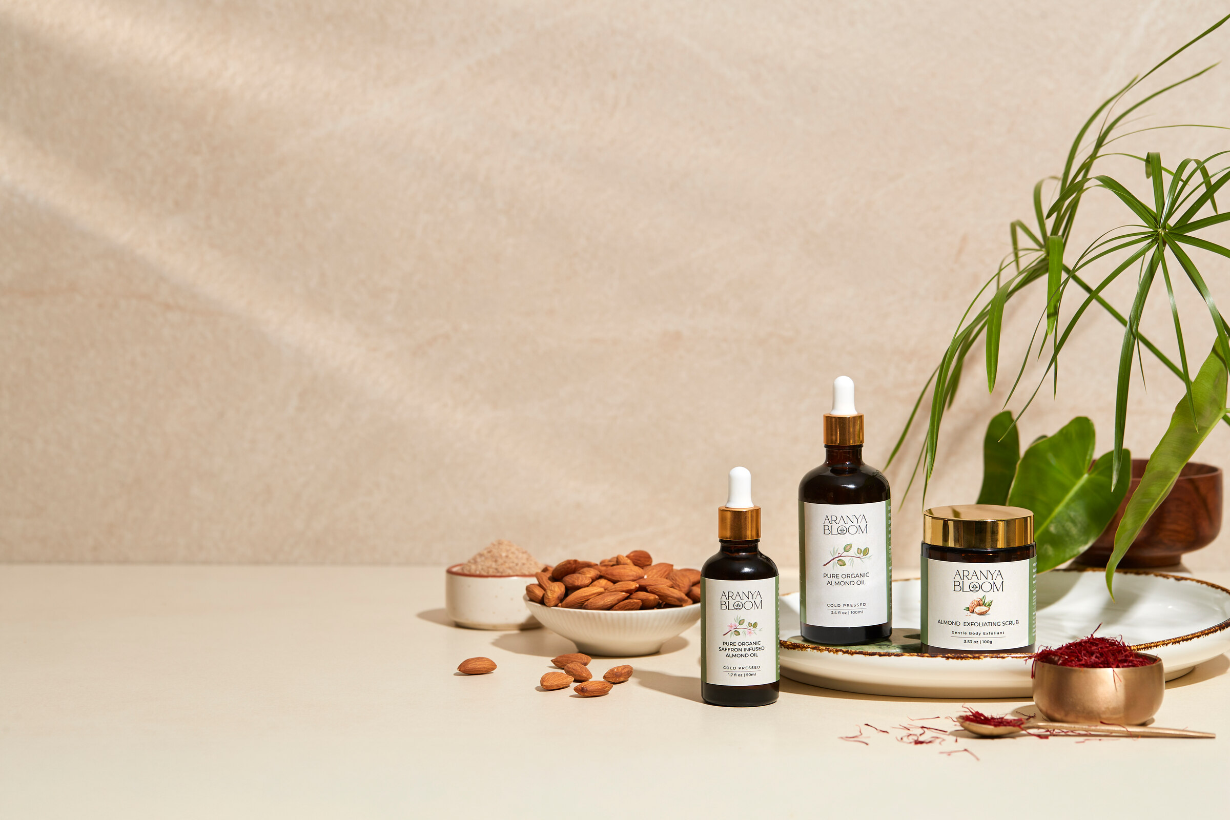 Aranya Bloom almond oils and body scrub arranged with almonds and saffron.